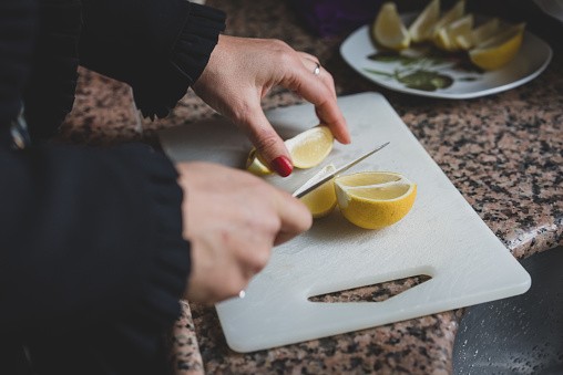 Closeup Of Woman Kitchen Cutting Lemons