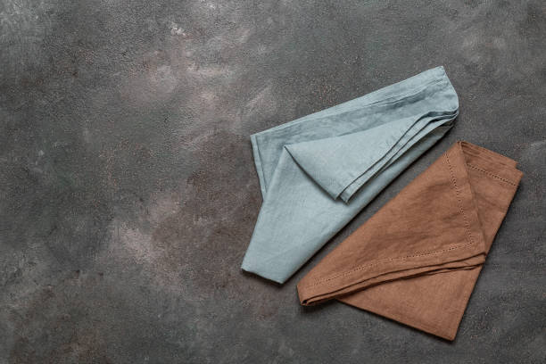 istock Two colored linen napkins lay flat on a dark background. Top view, copy space. 2018329066