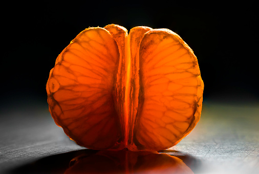 A macro shot of a backlit, peeled orange
