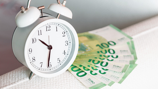 White vintage alarm clock and euro money, concept. Time of money and investments, creative idea. Savings and deposit