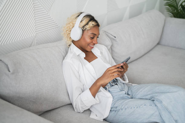 istock Modern technologies banner with copyspace. Happy african american looking at phone screen watching video,film,lostening to podcast etc. Social media,streaming service etc. 2018473114