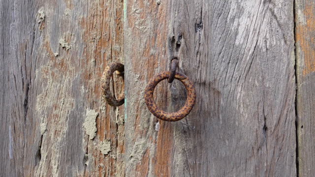 Rustic old wooden door and iron lock ring.
