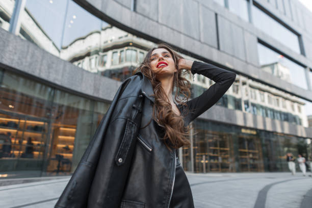 istock Happy beautiful chic model woman with red lips in fashionable clothes with a leather jacket walks and has fun in the city. Pretty lady 2018485903