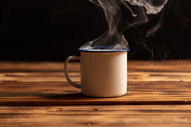 istock Mug with smoke, white coffee mug on rustic wood releasing smoke, dark background, selective focus. 2018495766