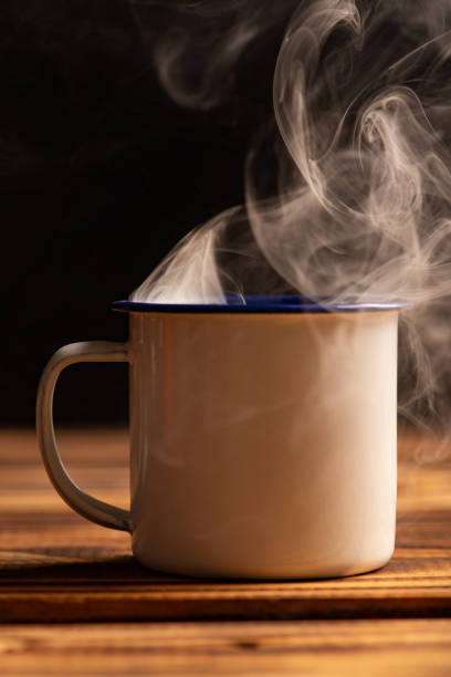 istock Mug with smoke, white coffee mug on rustic wood releasing smoke, dark background, selective focus. 2018495781