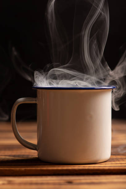 istock Mug with smoke, white coffee mug on rustic wood releasing smoke, dark background, selective focus. 2018495784
