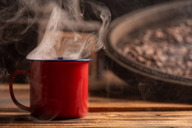 Coffee, red coffee mug on rustic wood and accessories, dark background, selective focus.
