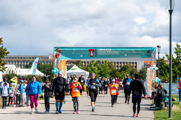 une course caritative est en cours dans le parc animé de prague - running marathon jogging track event photos et images de collection