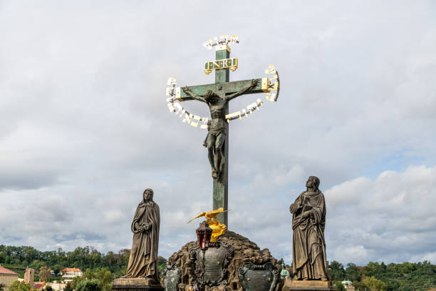 Prague, Capital City of Prague - Czech Republic - 09-18-2022: Baroque statues and crucifix on the Charles Bridge against a backdrop of Prague's skyline
