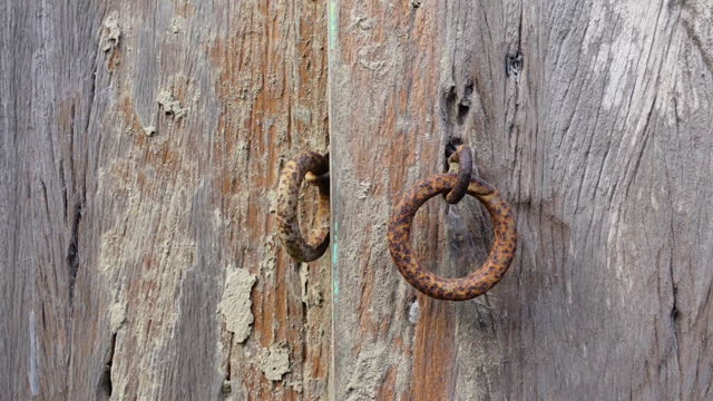 Rustic old wooden door and iron lock ring.