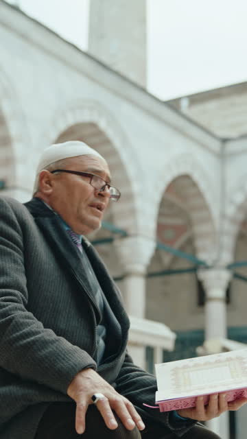 SLO MO Sacred Perspectives: Elderly Man During Quran Recital with Minarets in Backdrop Frame #MosqueCourtyard #QuranReading #SpiritualSerenity