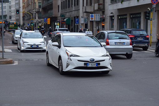 Milan, Italy - 28th May, 2018: Toyota Prius Hybrid taxi vehicles driving on a street. The Prius is the most popular taxi vehicle in Europe.