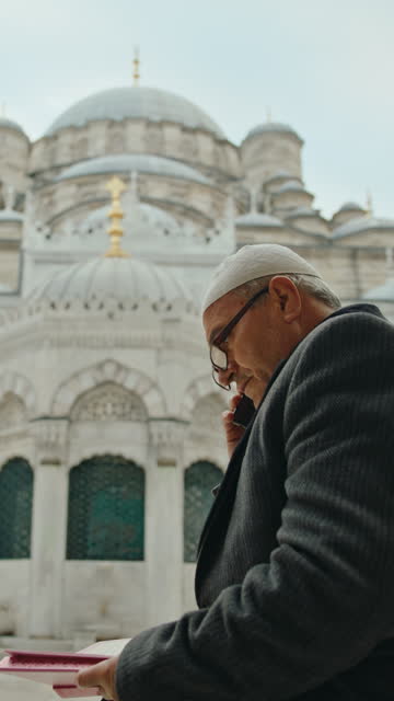 SLO MO Elderly Man Having a Call while he Reads Quran in the Courtyard of Mosque #MosqueCourtyard #QuranReading #SpiritualSerenity