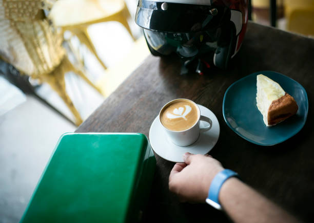 A motorcyclist's helmet and a cup of coffee on a table