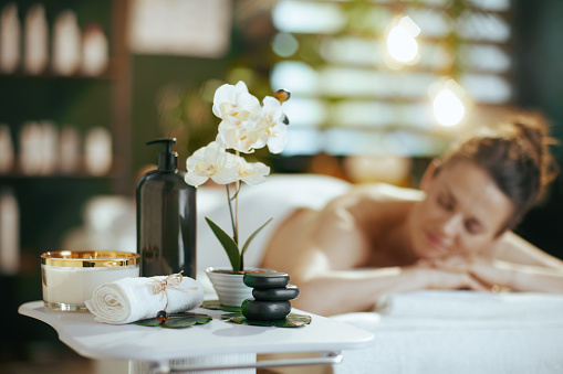 Healthcare time. Closeup spa composition. in background on relaxed woman in spa salon laying on massage table.