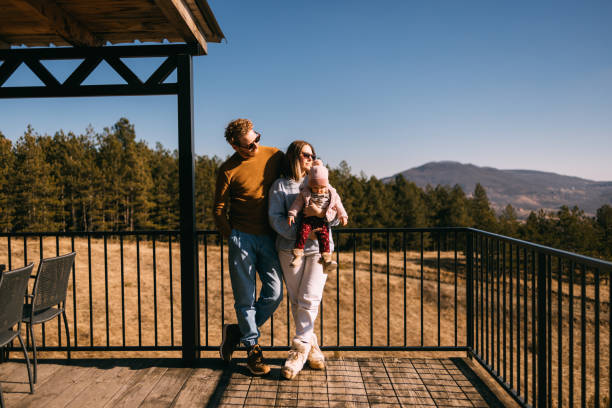 istock Family Enjoying a Sunny Day on a Mountain Cabin Deck 2018595081