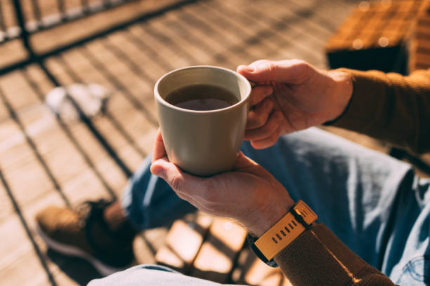 Person Relaxing with Coffee Cup on Sunny Deck