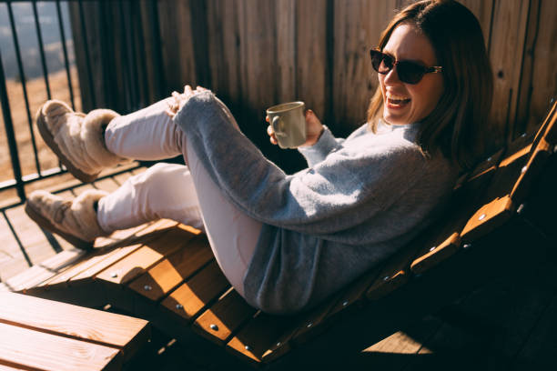 istock Smiling Woman Enjoying Coffee in Sunny Outdoor Setting 2018595104