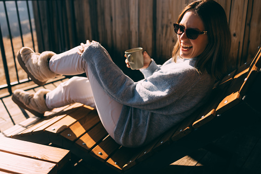 Happy young woman relaxing with a mug outdoors
