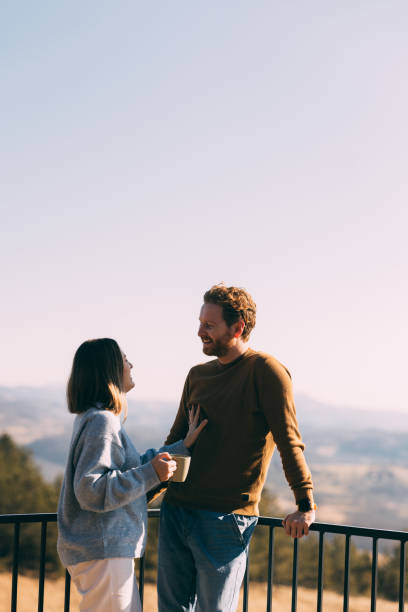 Affectionate Couple Enjoying a Warm Conversations Outdoor on a Balcony
