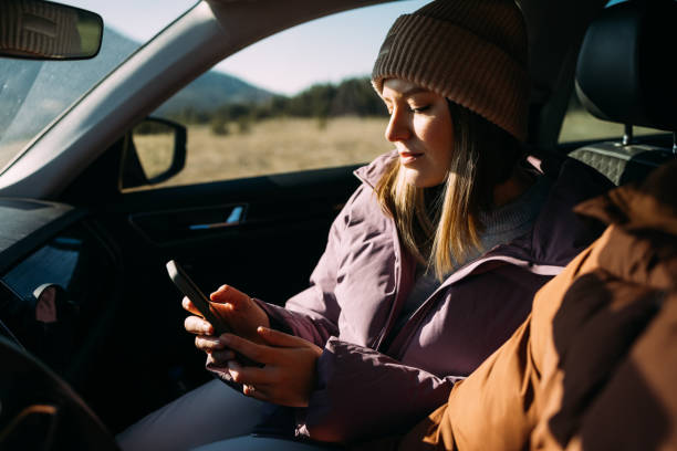 istock Young Woman Using Smartphone in Car on a Sunny Day 2018595631