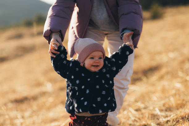istock First Steps of a Toddler Outside with Parent on a Sunny Day 2018596205
