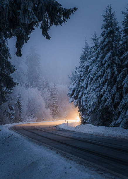 istock a car that is driving down the road in the winter 2018622672