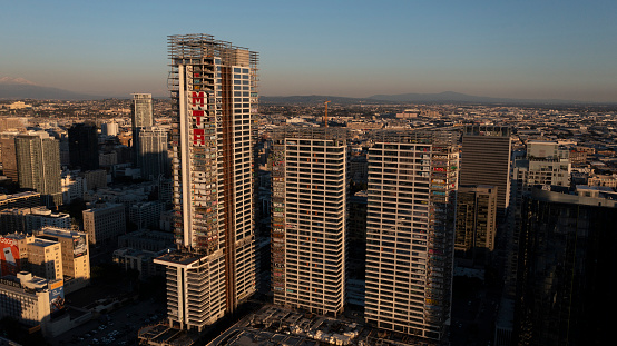 Los Angeles, California, USA - February 11, 2024: Sunset light shines on the abandoned and graffiti covered Oceanwide Plaza skyscrapers.