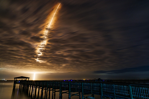 A United Launch Alliance Atlas V rocket heads to space from Cape Canaveral carrying a payload of an National Reconnaissance Office intelligence gathering satellite. The launch occurred just a few minutes after the sunset and the sun lit up the contrail as it rose.  Taken at Jetty Park in Cape Canaveral, a public viewing area.