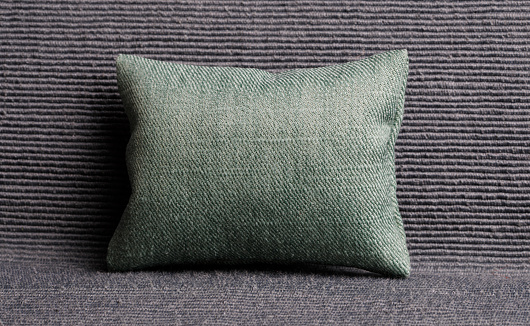 Olive green pillow on a gray sofa