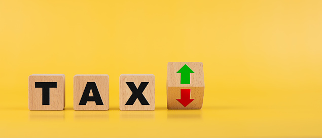 Tax fluctuation concept, Tax Increase or Decrease, Financial Planning, Tax rates, Taxation, Wooden block with text TAX and up and down symbol arrows on flipping block, Copy space.