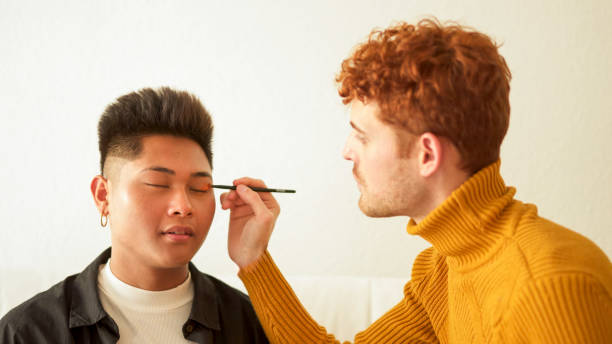 istock Concentrated gay man applying make up to her partner 2019345922