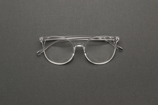 Stylish transparent glasses on a gray background. A fashionable tool for vision correction.