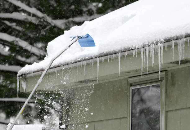 istock removing snow on the roof after snow storm 2019463264
