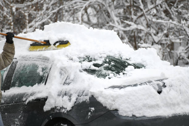 istock man removing snow on the car 2019464287