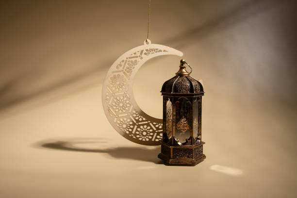 istock Ramadan Kareem moon and lantern on beige background, Eastern tradition, candle burn 2019486405