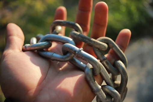 man hold heavy chain in hand