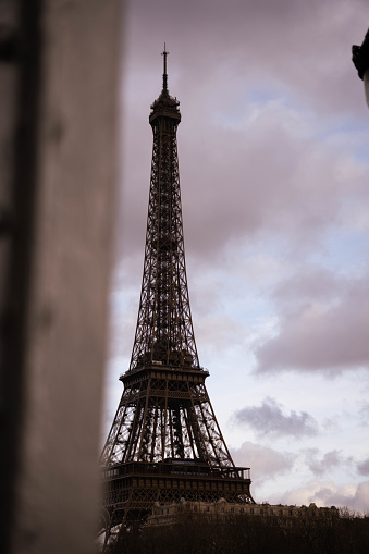 The iconic Eiffel Tower stands tall in Paris, France, set against a dramatic cloudy sky