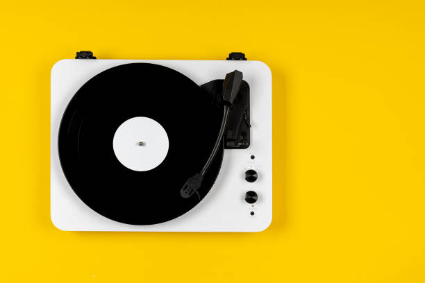 istock Vinyl turntable with vinyl plate on a yellow background. Modern gramophone record player. Retro sound technology to play music 2019625410