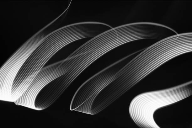White neon glowing wave of light with smooth stripes on black background, striped pattern. Abstract background with motion light effect, light painting in disco party style.