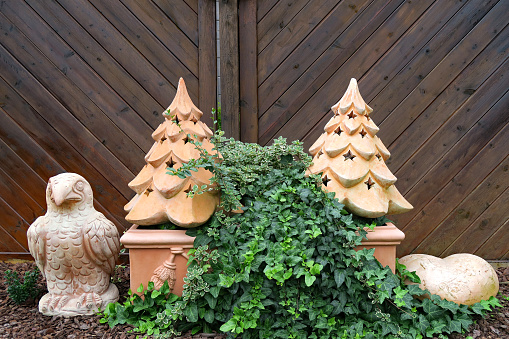 Garden design with ivy plant and christmas trees, heart and bird made of stone material.