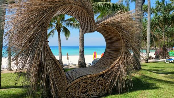 istock Tropical beach view through unique wooden structure with palm trees 2019677878