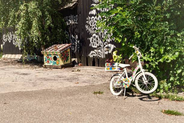 Zalipie, Poland - August 9, 2022: Bicycle and colorful wooden house for a dog in the yard in the village in summer.