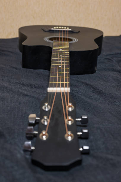 istock Black acoustic guitar on a black background 2019692802