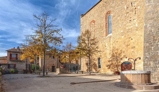 In Monticchiello, Tuscany, Italy, the main square exudes medieval charm with its quaint village scene. Dominating the square is a picturesque church, surrounded by rustic buildings that evoke a sense of history and timelessness.