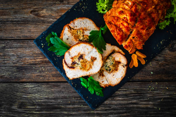 stuffed turkey breast roulade with dried apricots and cranberries on wooden table - filet mignon bacon fillet steak - fotografias e filmes do acervo