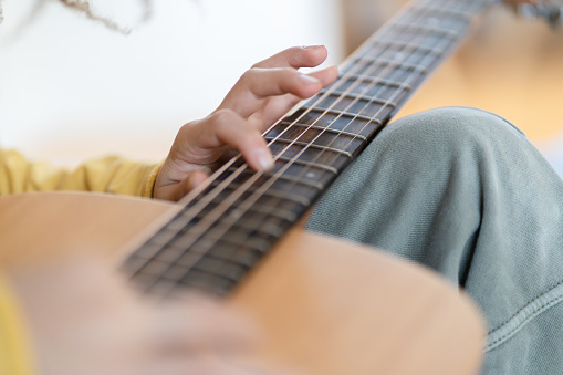 Close up of hands of a child on a guitar, selective focus