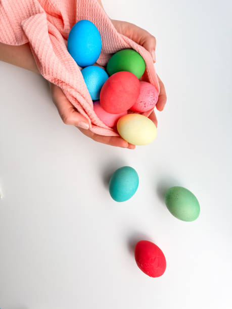 istock Hands cradling collection of brightly colored Easter eggs in pink fabric, evoking themes of Easter traditions, family fun, and springtime crafts. 2019757196