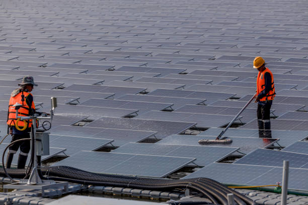 istock Worker Cleaning  floating solar panels or solar cell Platform system on the lake with brush and water. Worker cleaning solar modules in a Solar Energy Power Plant 2019757556