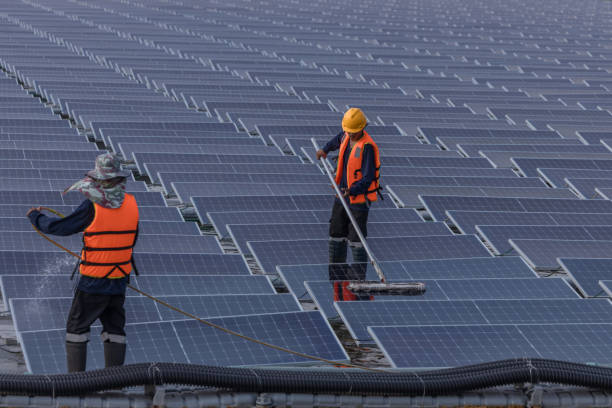 istock Worker Cleaning  floating solar panels or solar cell Platform system on the lake with brush and water. Worker cleaning solar modules in a Solar Energy Power Plant 2019757577